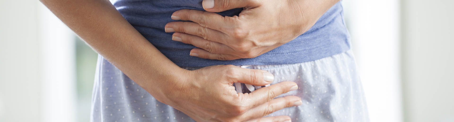 Femme se tient le ventre de douleur