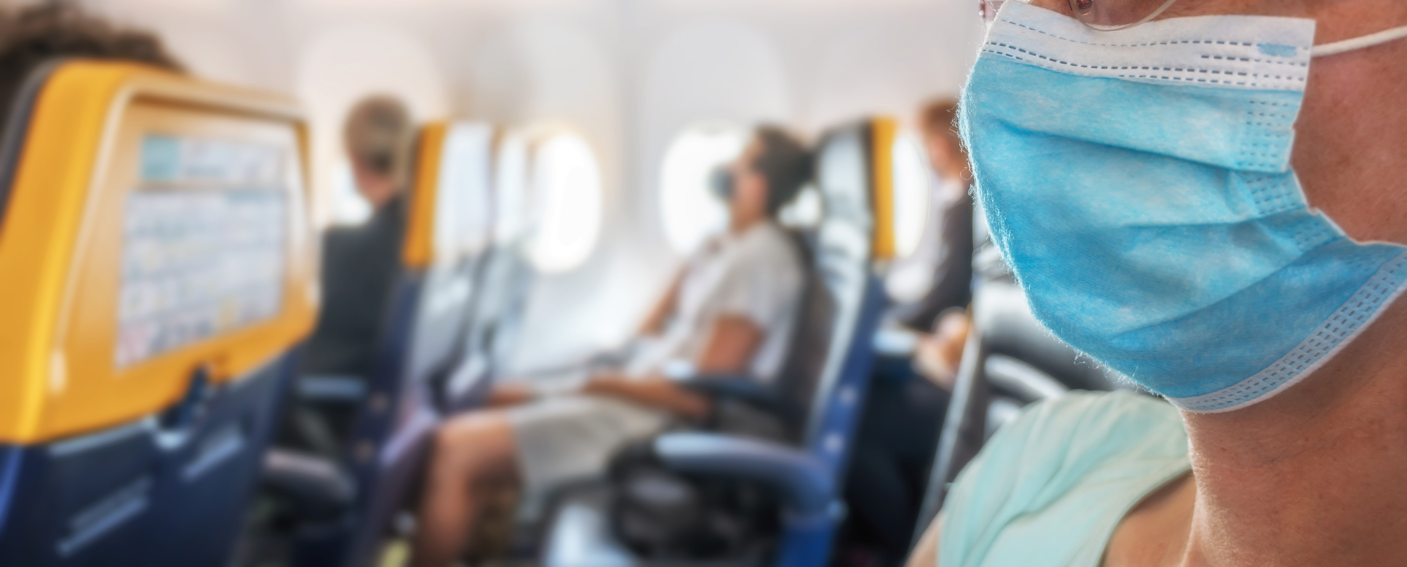 Bild: Personen mit Maske im Flugzeug