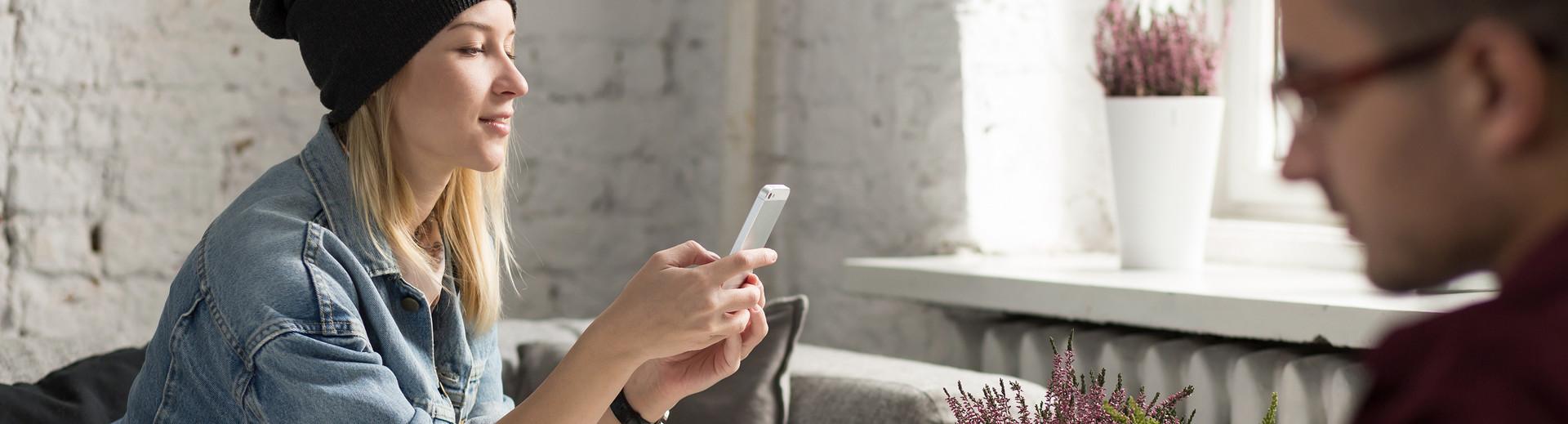 Une jeune femme avec un smartphone s'informe