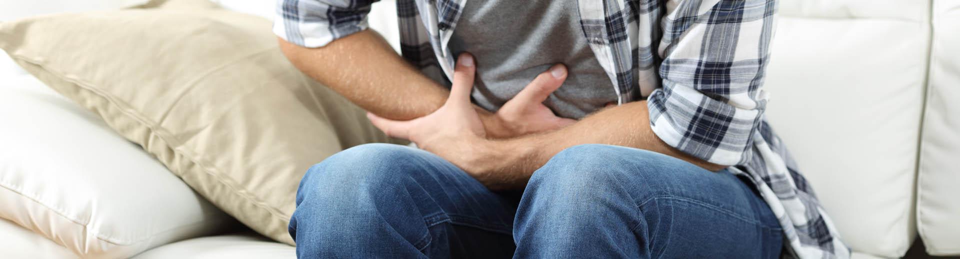 Homme se tient le ventre de douleur